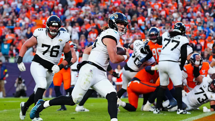 Dec 21, 2025; Denver, Colorado, USA; Jacksonville Jaguars quarterback Trevor Lawrence (16) rushes for a touchdown against the Denver Broncos during the second  half at Empower Field at Mile High. Mandatory Credit: Ron Chenoy-Imagn Images