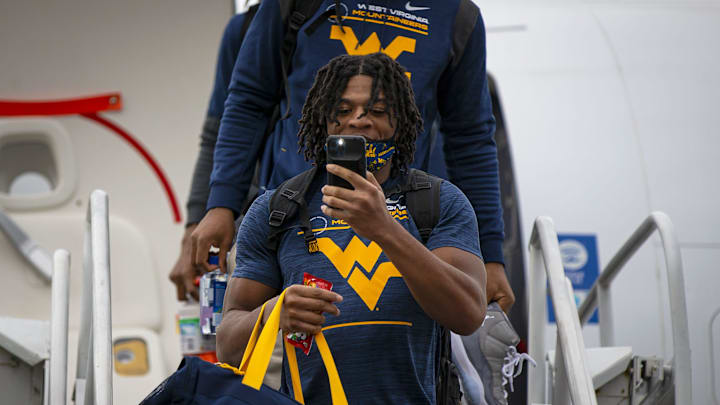 A member of the West Virginia University football team records a crowd welcoming the team to Phoenix on the tarmac at Sky Harbor Airport on Dec. 25, 2021. Monica D. Spencer/The Republic 8999353002

Wvu Guaranteed Rate Bowl 8999353002 10