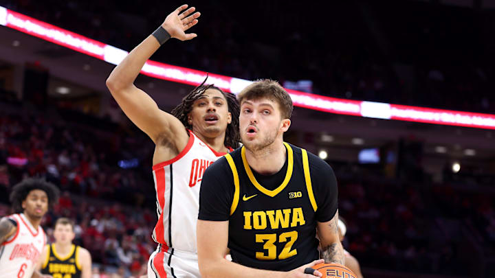 Jan 27, 2025; Columbus, Ohio, USA;  Iowa Hawkeyes forward Owen Freeman (32) controls the ball as Ohio State Buckeyes forward Devin Royal (21) defends during the first half at Value City Arena. Mandatory Credit: Joseph Maiorana-Imagn Images