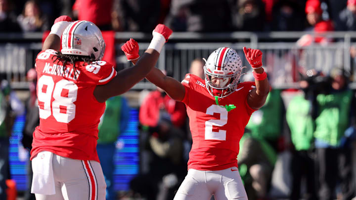 Nov 30, 2024; Columbus, Ohio, USA; Ohio State Buckeyes safety Caleb Downs (2) celebrates a fourth down stop with Ohio State Buckeyes defensive lineman Kayden McDonald (98) during the first quarter against the Michigan Wolverines at Ohio Stadium. Mandatory Credit: Joseph Maiorana-Imagn Images