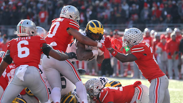 Nov 30, 2024; Columbus, Ohio, USA;  Michigan Wolverines running back Kalel Mullings (20) dives for the first down as Ohio State Buckeyes linebacker Cody Simon (0) and safety Caleb Downs(2) make the stop during the second half at Ohio Stadium. Mandatory Credit: Joseph Maiorana-Imagn Images