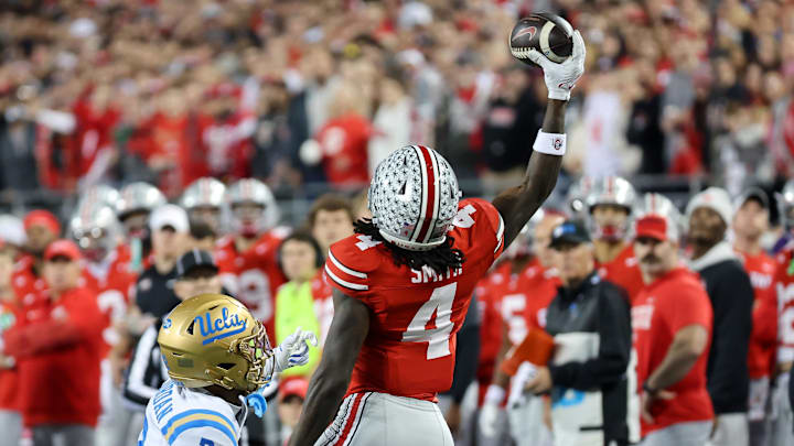 Nov 15, 2025; Columbus, Ohio, USA;  Ohio State Buckeyes wide receiver Jeremiah Smith (4) makes a one handed first down catch as UCLA Bruins defensive back Andre Jordan Jr. (2) defends during the first quarter at Ohio Stadium. Mandatory Credit: Joseph Maiorana-Imagn Images