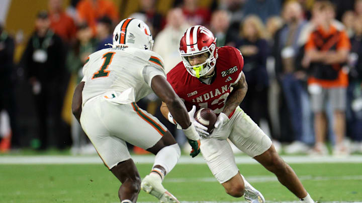 Jan 19, 2026; Miami Gardens, FL, USA; Indiana Hoosiers wide receiver Elijah Sarratt (13) makes a catch against Miami Hurricanes linebacker Mohamed Toure (1) in the second half during the College Football Playoff National Championship game at Hard Rock Stadium. Mandatory Credit: Nathan Ray Seebeck-Imagn Images
