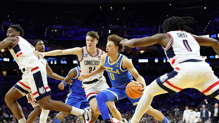 Mar 22, 2026; Philadelphia, PA, USA; UCLA Bruins guard Trent Perry (0) dribbles the ball past UConn Huskies guard Braylon Mullins (24) in the second half during a second round game of the men's 2026 NCAA Tournament at Xfinity Mobile Arena. Mandatory Credit: Bill Streicher-Imagn Images