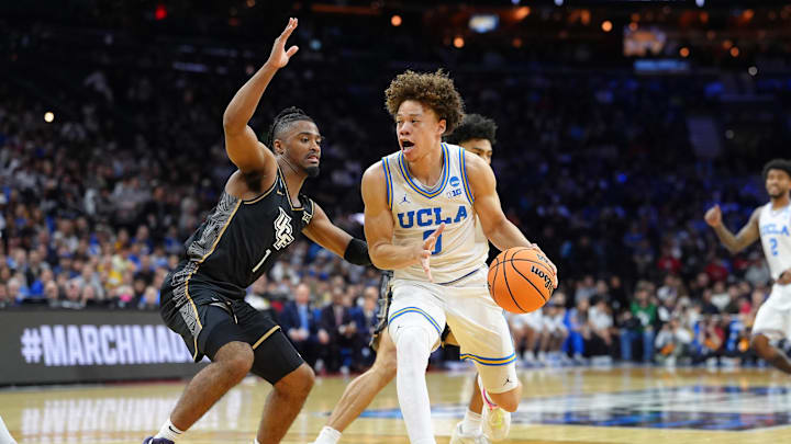 Mar 20, 2026; Philadelphia, PA, USA; UCLA Bruins guard Trent Perry (0) dribbles the ball against UCF Knights guard Themus Fulks (1) in the first half during a first round game of the men's 2026 NCAA Tournament at Xfinity Mobile Arena. Mandatory Credit: Kyle Ross-Imagn Images