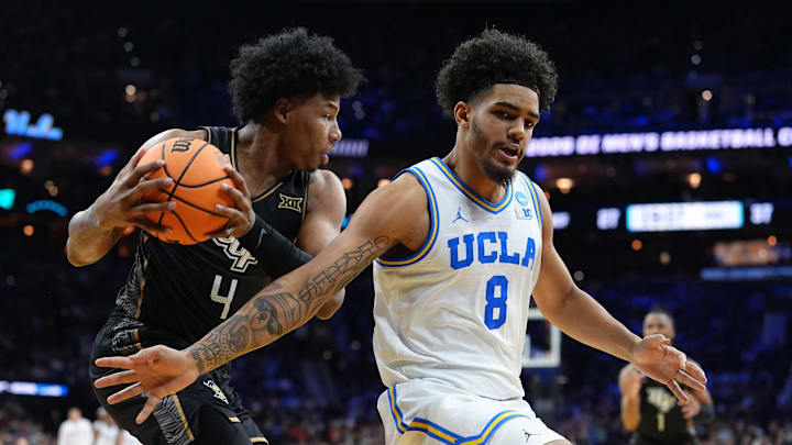 Mar 20, 2026; Philadelphia, PA, USA; UCF Knights forward Jamichael Stillwell (4) grabs a rebound against UCLA Bruins guard Eric Freeny (8) in the second half during a first round game of the men's 2026 NCAA Tournament at Xfinity Mobile Arena. Mandatory Credit: Kyle Ross-Imagn Images