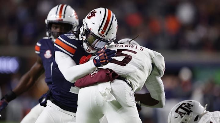Nov 23, 2024; Auburn, Alabama, USA;  Texas A&M Aggies running back Amari Daniels (5) is tackled by Auburn Tigers safety Kaleb Harris (18) during the second quarter at Jordan-Hare Stadium. Mandatory Credit: John Reed-Imagn Images