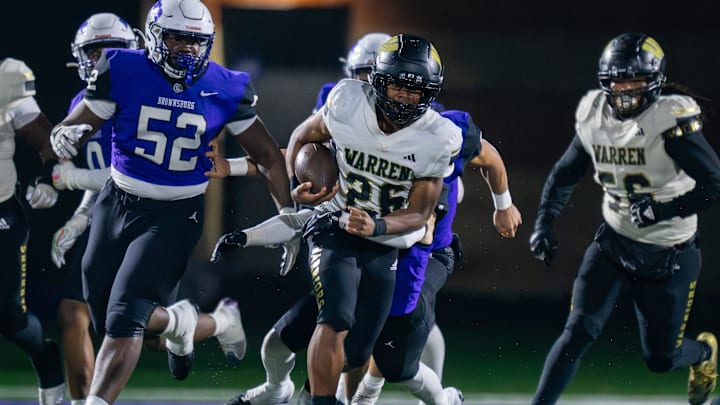 Warren Central High School senior Keyon Thomas (26) runs the ball out of the backfield during the first half of an IHSAA Class 6A semi-state football game against Brownsburg High School, Friday, Nov. 21, 2025, at Brownsburg High School.