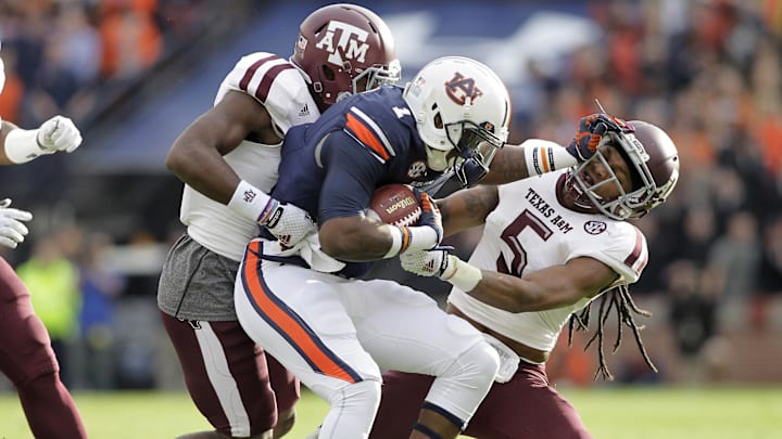 Nov 8, 2014; Auburn, AL, USA; Auburn Tigers receiver receiver D'haquille Williams (1) is tackled by Texas A&M Aggies defensive backs Floyd Raven, Sr. (5) and Devonta Burns (26) during the first half at Jordan Hare Stadium. Mandatory Credit: John Reed-Imagn Images