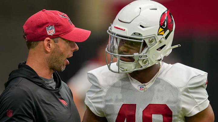 Jonathan Gannon, Arizona Cardinals head coach, left, speaks Kyler McMichael (48), right, during the