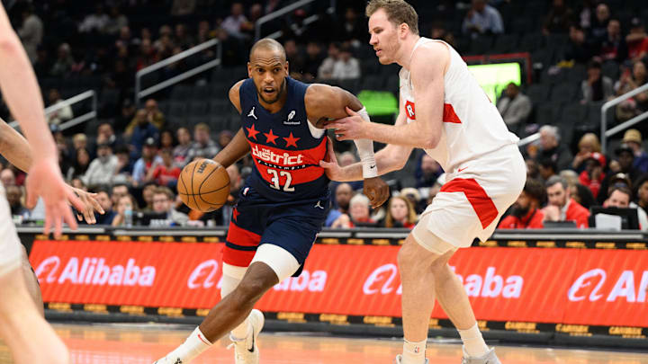 Mar 24, 2025; Washington, District of Columbia, USA; Washington Wizards forward Khris Middleton (32) drives to the basket against Toronto Raptors center Jakob Poeltl (19) during the second quarter at Capital One Arena. Mandatory Credit: Reggie Hildred-Imagn Images