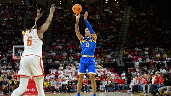 Jan 10, 2025; College Park, Maryland, USA; UCLA Bruins guard Kobe Johnson (0) takes a jump shot over Maryland Terrapins forward Tafara Gapare (6) during the first half at Xfinity Center. Mandatory Credit: Reggie Hildred-Imagn Images