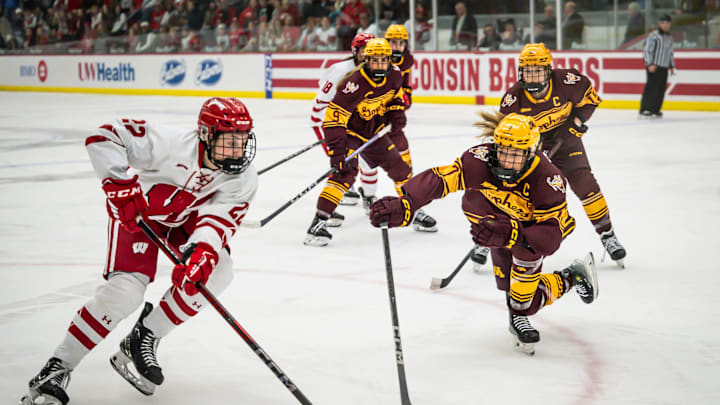 Wisconsin Badgers defender Emma Venusio (22) works her way past Minnesota Gophers defender Nelli Laitinen (7) in a game Saturday, February 8, 2025, at LaBahn Arena in Madison, Wisconsin.