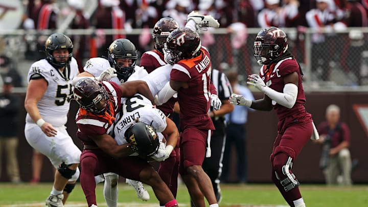 Oct 14, 2023; Blacksburg, Virginia, USA; Wake Forest Demon Deacons running back Tate Carney (30) is tackled by Virginia Tech Hokies defensive lineman Cole Nelson (17) during the second quarter  at Lane Stadium. Mandatory Credit: Peter Casey-Imagn Images