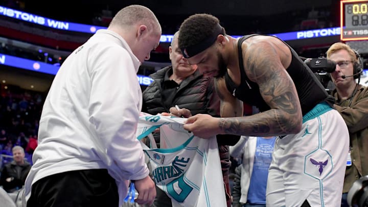 Mar 11, 2024; Detroit, Michigan, USA;  Charlotte Hornets forward Miles Bridges (0) signs his game jersey for a fan after their game against the Detroit Pistons at Little Caesars Arena. Mandatory Credit: Lon Horwedel-Imagn Images