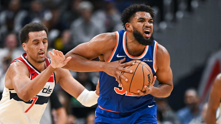 Oct 18, 2024; Washington, District of Columbia, USA; New York Knicks center Karl-Anthony Towns (32) reacts while being defended by Washington Wizards forward Patrick Baldwin Jr. (7) during the second quarter at Capital One Arena. Mandatory Credit: Reggie Hildred-Imagn Images