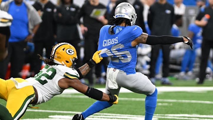 Nov 23, 2023; Detroit, Michigan, USA; Detroit Lions running back Jahmyr Gibbs (26) gets pulled down by his jersey from behind by Green Bay Packers linebacker Rashan Gary (52) in the second quarter at Ford Field. Mandatory Credit: Lon Horwedel-Imagn Images