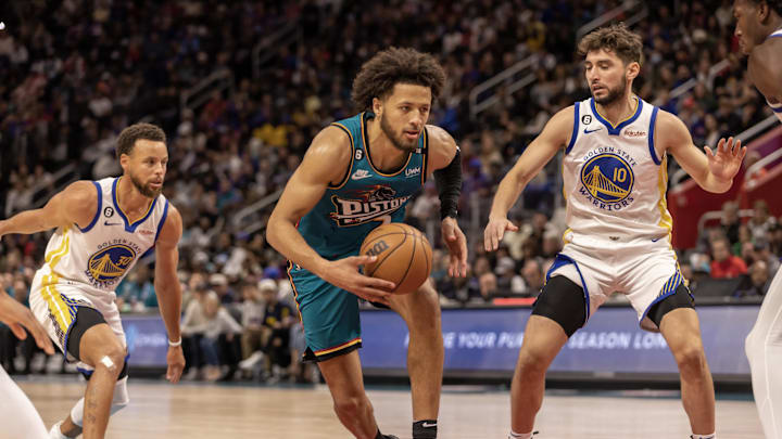 Oct 30, 2022; Detroit, Michigan, USA; Detroit Pistons guard Cade Cunningham (2) drives to the basket between Golden State Warriors guard Stephen Curry (30) and guard Ty Jerome (10) during  the second half at Little Caesars Arena. Mandatory Credit: David Reginek-Imagn Images