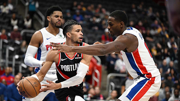 Jan 6, 2025; Detroit, Michigan, USA; Portland Trail Blazers forward Toumani Camara (33) looks to pass the ball past Detroit Pistons center Jalen Duren (0) under the basket in the first quarter at Little Caesars Arena. Mandatory Credit: Lon Horwedel-Imagn Images