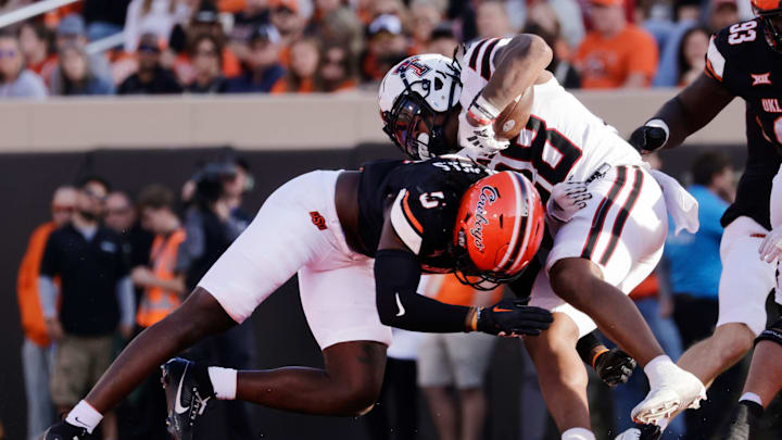 Texas Tech's Tahj Brooks is taken down by Oklahoma State's Kendal Daniels during an NCAA football game on Saturday, Nov. 23, 2024, in Stillwater, Okla.