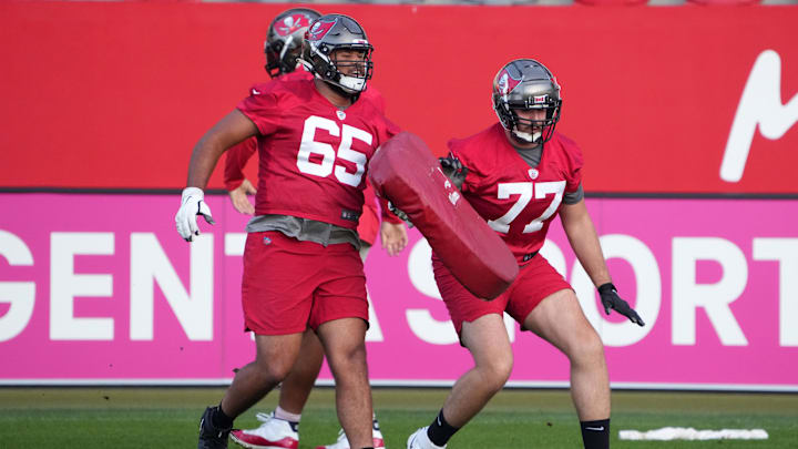 Nov 11, 2022; Munich, Germany; Tampa Bay Buccaneers offensive tackle Dylan Cook (65) and offensive tackle Justin Skule (77) participate in drills during practice at the FC Bayern Campus. Mandatory Credit: Kirby Lee-Imagn Images