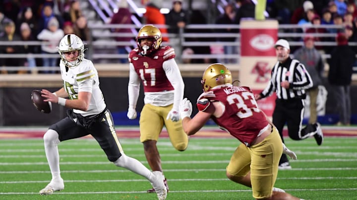 Nov 15, 2025; Chestnut Hill, Massachusetts, USA; Georgia Tech Yellow Jackets quarterback Haynes King (10) runs with the ball while Boston College Eagles linebacker Owen McGowan (33) defends during the first half at Alumni Stadium. Mandatory Credit: Bob DeChiara-Imagn Images