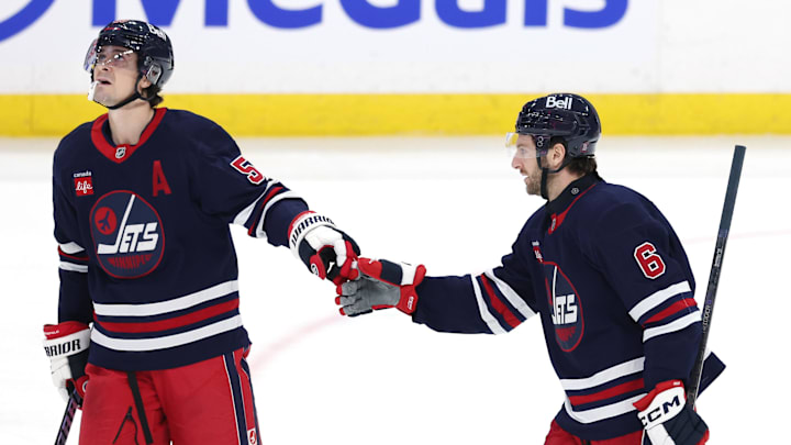 Mar 23, 2025; Winnipeg, Manitoba, CAN; Winnipeg Jets defenseman Colin Miller (6) celebrates after a goal against the Buffalo Sabres with Winnipeg Jets center Mark Scheifele (55) in the third period at Canada Life Centre. Mandatory Credit: James Carey Lauder-Imagn Images