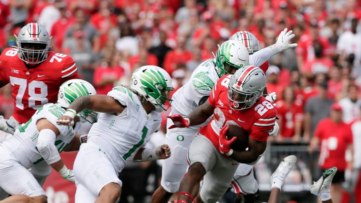 Ohio State Buckeyes running back Miyan Williams (28) is pursued by Oregon Ducks linebacker Noah Sewell (1) during Saturday's NCAA Division I football game at Ohio Stadium in Columbus on September 11, 2021.