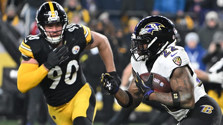 Baltimore Ravens running back Derrick Henry (22) rushes the ball past Pittsburgh Steelers linebacker T.J. Watt (90) during the first half at Acrisure Stadium. 