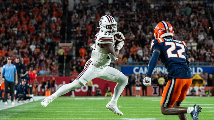 Dec 31, 2024; Orlando, FL, USA; South Carolina Gamecocks running back Oscar Adaway III (27) makes the catch against Illinois Fighting Illini defensive back Kaleb Patterson (22) in the fourth quarter at Camping World Stadium. Mandatory Credit: Jeremy Reper-Imagn Images