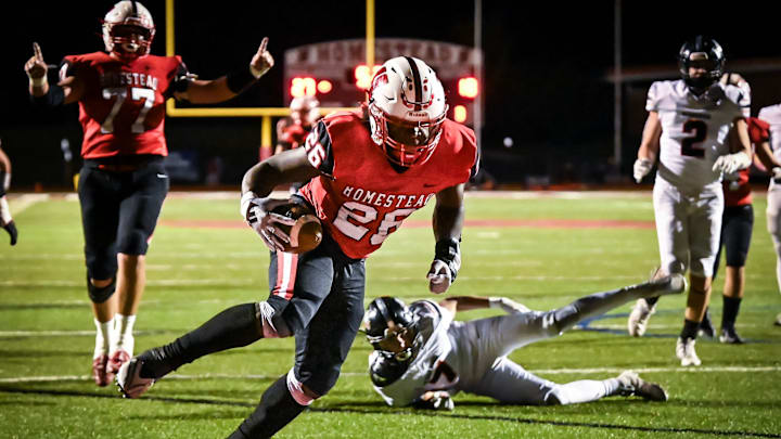 Homestead running back Bentley Hickman (26) stumbles into the end zone for a 16-yard touchdown against Cedarburg during the fourth quarter in a game Friday, October 4, 2024, at Homestead High School in Mequon, Wisconsin.