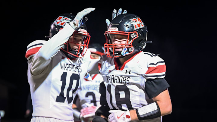 Muskego defensive back Cole Reid (10) congratulates teammate Jack Labisch (18) after a touchdown on November 1, 2024.