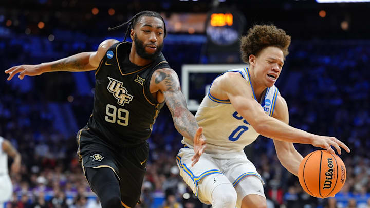 Mar 20, 2026; Philadelphia, PA, USA; UCLA Bruins guard Trent Perry (0) dribbles the ball past UCF Knights forward Jordan Burks (99) in the second half during a first round game of the men's 2026 NCAA Tournament at Xfinity Mobile Arena. Mandatory Credit: Kyle Ross-Imagn Images