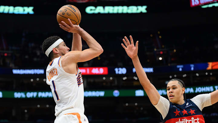 Jan 16, 2025; Washington, District of Columbia, USA; Phoenix Suns guard Devin Booker (1) shoots a three point shot against Washington Wizards forward Kyshawn George (18) during the fourth quarter at Capital One Arena. Mandatory Credit: Reggie Hildred-Imagn Images