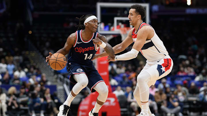 Nov 27, 2024; Washington, District of Columbia, USA; LA Clippers guard Terance Mann (14) handles the ball against Washington Wizards forward Patrick Baldwin Jr. (7) during the fourth quarter at Capital One Arena. Mandatory Credit: Reggie Hildred-Imagn Images