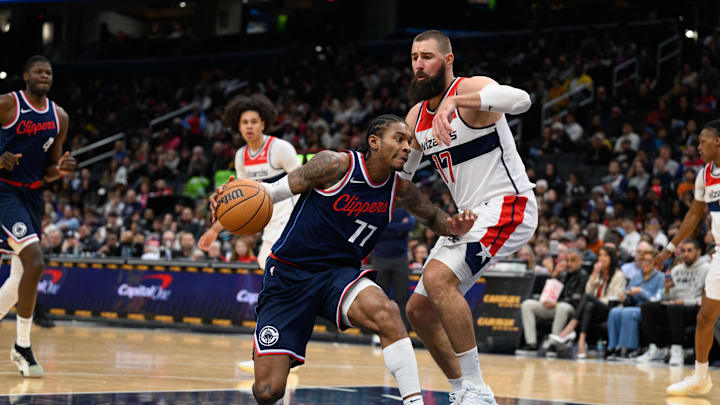 Nov 27, 2024; Washington, District of Columbia, USA; LA Clippers guard Kevin Porter Jr. (77) drives to the basket against Washington Wizards center Jonas Valanciunas (17) during the fourth quarter  at Capital One Arena. Mandatory Credit: Reggie Hildred-Imagn Images