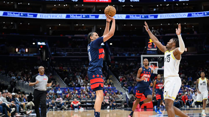 Mar 5, 2025; Washington, District of Columbia, USA; Washington Wizards forward Kyshawn George (18) takes a jump shot over Utah Jazz guard Isaiah Collier (13) during the second quarter at Capital One Arena. Mandatory Credit: Reggie Hildred-Imagn Images