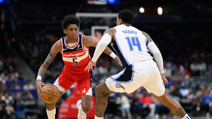 Mar 21, 2025; Washington, District of Columbia, USA; Washington Wizards guard AJ Johnson (5) handles the ball against Orlando Magic guard Gary Harris (14) during the third quarter at Capital One Arena. Mandatory Credit: Reggie Hildred-Imagn Images