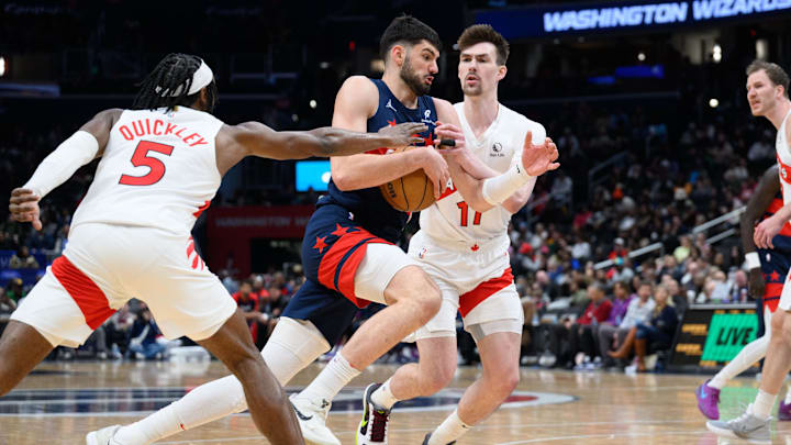 Mar 24, 2025; Washington, District of Columbia, USA; Washington Wizards forward Tristan Vukcevic (00) drives to the basket against Toronto Raptors guard Immanuel Quickley (5) during the third quarter at Capital One Arena. Mandatory Credit: Reggie Hildred-Imagn Images