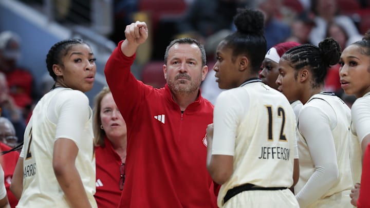 U of L head coach Jeff Walz huddles his team during their game against Virginia at the KFC Yum! Center in Louisville, Ky. on Feb. 25, 2024.