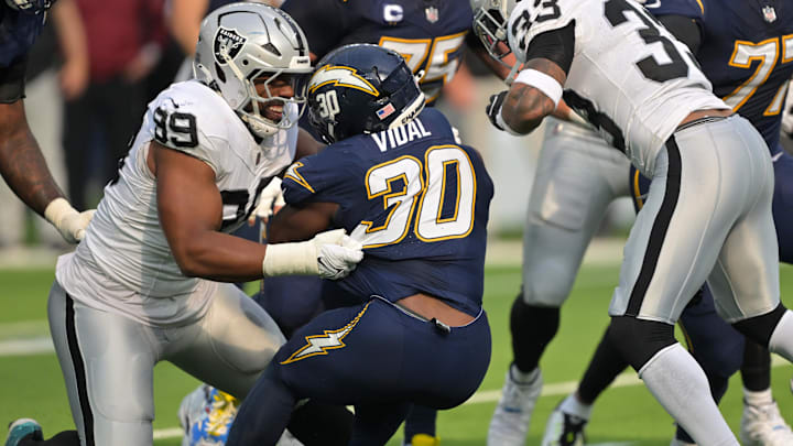 Nov 30, 2025; Inglewood, California, USA; Las Vegas Raiders defensive tackle Thomas Booker IV (99) tackles Los Angeles Chargers running back Kimani Vidal (30) during the first half at SoFi Stadium. Mandatory Credit: Jayne Kamin-Oncea-Imagn Images