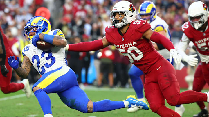 Dec 7, 2025; Glendale, Arizona, USA; Los Angeles Rams running back Kyren Williams (23) rushes the ball past Arizona Cardinals linebacker Cody Simon (50) during the second half at State Farm Stadium. Mandatory Credit: Mark J. Rebilas-Imagn Images