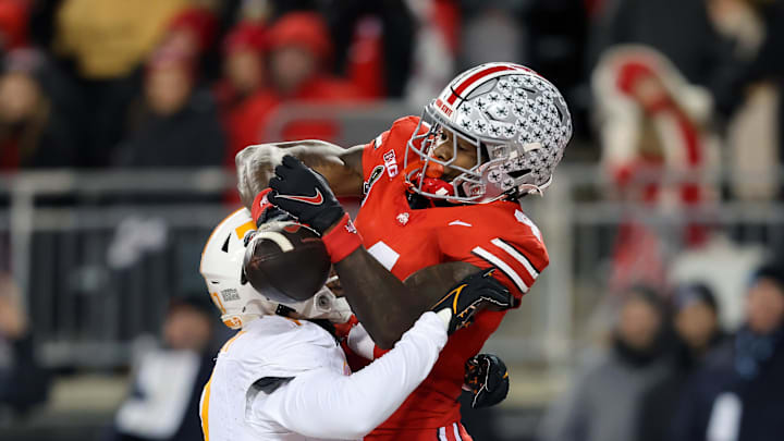 Dec 21, 2024; Columbus, Ohio, USA; Ohio State Buckeyes wide receiver Jeremiah Smith (4) goes for the ball as Tennessee Volunteers linebacker Arion Carter (7) defends during the second quarter at Ohio Stadium. Mandatory Credit: Joseph Maiorana-Imagn Images Dec 21, 2024; Columbus, Ohio, USA; Ohio State Buckeyes wide receiver Jeremiah Smith (4) goes for the ball as Tennessee Volunteers linebacker Arion Carter (7) defends during the second quarter at Ohio Stadium. Mandatory Credit: Joseph Maiorana-Imagn Images