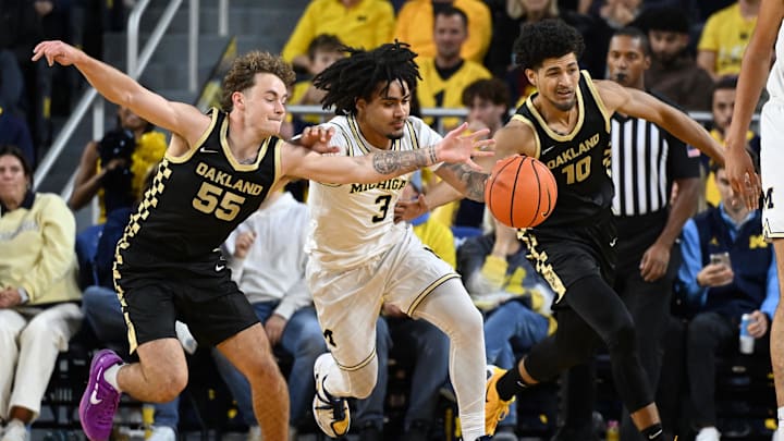 Nov 3, 2025; Ann Arbor, Michigan, USA; Michigan Wolverines guard Elliot Cadeau (3) battles for a loose ball with Oakland Golden Grizzlies guards Brody Robinson (55) and  Brett White (10) in the first half at Crisler Center. Mandatory Credit: Lon Horwedel-Imagn Images