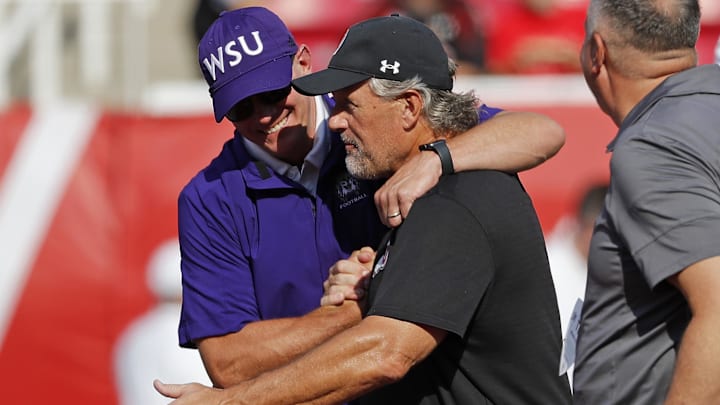 Sep 2, 2021; Salt Lake City, Utah, USA; Weber State Wildcats head coach Jay Hill, left and Utah Utes head coach Kyle Whittingham get together prior to their game  at Rice-Eccles Stadium. Mandatory Credit: Jeffrey Swinger-Imagn Images