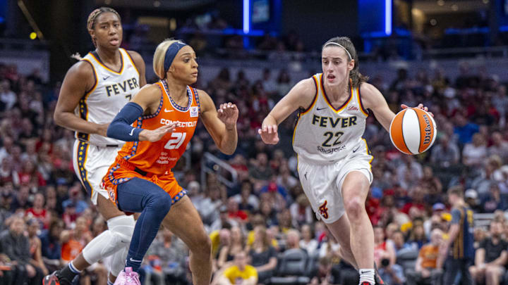 Indiana Fever guard Caitlin Clark (22) brings the ball up court while being defended by Connecticut Sun guard DiJonai Carrington (21) during the first half of an WNBA basketball game, Monday, May 20, 2024, at Gainbridge Fieldhouse.