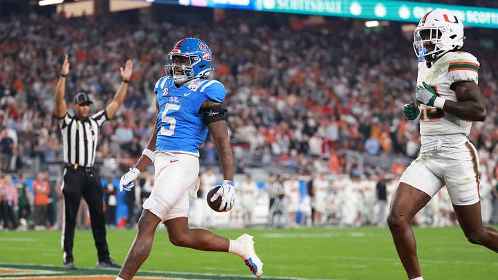Jan 8, 2026; Glendale, AZ, USA; Mississippi Rebels running back Kewan Lacy (5) rushes the ball for a touchdown against Miami Hurricanes defensive back Jr. Romanas Frederique (29) in the first half during the 2026 Fiesta Bowl and semifinal game of the College Football Playoff at State Farm Stadium. Mandatory Credit: Mark J. Rebilas-Imagn Images Jan 8, 2026; Glendale, AZ, USA; Mississippi Rebels running back Kewan Lacy (5) rushes the ball for a touchdown against Miami Hurricanes defensive back Jr. Romanas Frederique (29) in the first half during the 2026 Fiesta Bowl and semifinal game of the College Football Playoff at State Farm Stadium. Mandatory Credit: Mark J. Rebilas-Imagn Images