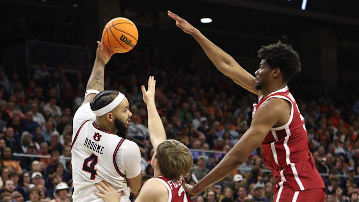 Feb 4, 2025; Auburn, Alabama, USA;  Auburn Tigers forward Johni Broome (4) makes a pass over Oklahoma Sooners forward Mohamed Wague (5) and guard Dayton Forsythe (7) during the second half at Neville Arena. Mandatory Credit: John Reed-Imagn Images