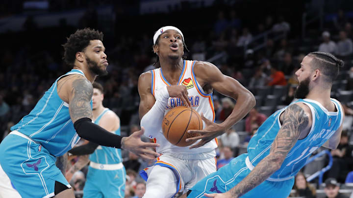 Mar 14, 2022; Oklahoma City, Oklahoma, USA; Oklahoma City Thunder guard Shai Gilgeous-Alexander (2) drives to the basket between Charlotte Hornets forward Miles Bridges (0) and forward Cody Martin (11) during the second half at Paycom Center. Charlotte won 134-116. Mandatory Credit: Alonzo Adams-Imagn Images
