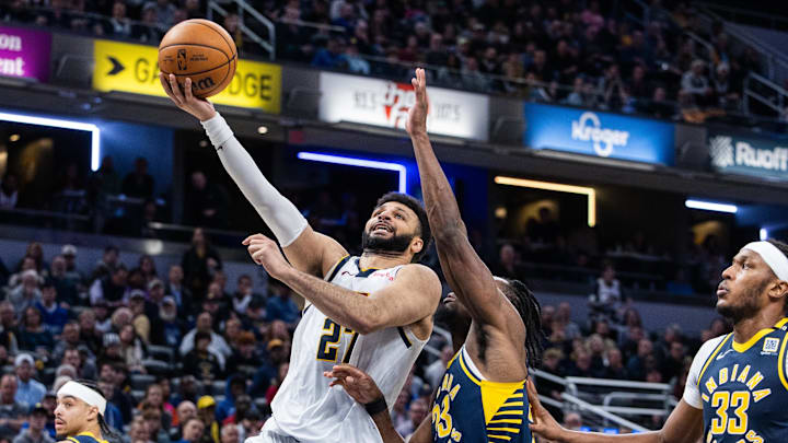 Jan 23, 2024; Indianapolis, Indiana, USA; Denver Nuggets guard Jamal Murray (27) shoots the ball while Indiana Pacers forward Aaron Nesmith (23) defends in the second half at Gainbridge Fieldhouse. Mandatory Credit: Trevor Ruszkowski-Imagn Images